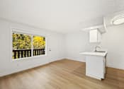 Thumbnail 36 of 49 - A kitchen with a white fridge and a window with a view of trees.