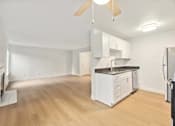 Thumbnail 2 of 26 - A kitchen with white cabinets and a wooden floor.