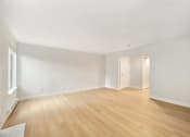 Thumbnail 4 of 26 - A room with wooden floors and white walls.
