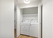 Thumbnail 8 of 26 - A white laundry room with a washer and dryer.