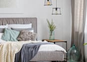 Thumbnail 3 of 8 - A grey bed with a grey blanket and pillows with a white pillowcase.