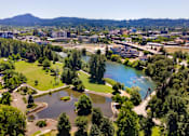 Thumbnail 2 of 8 - A beautiful aerial view of a park with a lake and a bridge.
