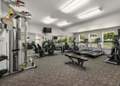Thumbnail 20 of 24 - a gym with cardio equipment and weights in a room with windows