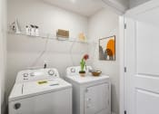 Thumbnail 27 of 31 - a small laundry room with a washer and dryer and a sink