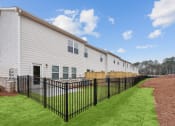 Thumbnail 30 of 31 - the exterior of a building with a yard and a fence