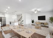Thumbnail 9 of 31 - a living room and dining room with a table and chairs