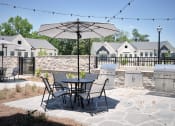Thumbnail 15 of 48 - a patio with a table and chairs under an umbrella