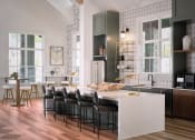 Thumbnail 8 of 48 - a kitchen with a white marble counter top and black chairs