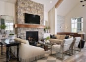 Thumbnail 10 of 48 - a living room with a stone fireplace and furniture