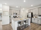Thumbnail 22 of 48 - a kitchen with a large island with two stools