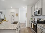 Thumbnail 24 of 48 - a renovated kitchen with granite counter tops and white cabinets