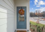 Thumbnail 20 of 48 - a blue door on a white house with a wreath on it