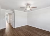 Thumbnail 20 of 31 - an empty living room with white walls and a ceiling fan