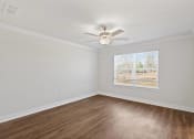 Thumbnail 24 of 31 - an empty living room with a ceiling fan and a window
