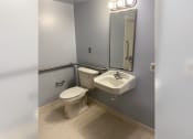 Thumbnail 8 of 22 - a bathroom with a toilet and a sink and a mirror