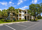 Thumbnail 1 of 15 - A large building with a parking lot in front of it.