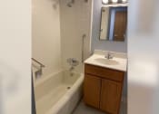 Thumbnail 12 of 22 - a bathroom with a sink and a tub and a mirror