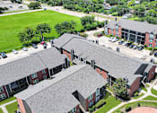 Thumbnail 24 of 26 - A large building complex with a green lawn in front.