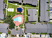 Thumbnail 21 of 26 - A bird's eye view of a residential area with houses, cars, and a swimming pool.