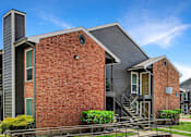 Thumbnail 16 of 26 - A modern brick house with a grey roof and a balcony.