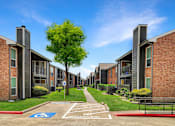 Thumbnail 15 of 26 - A row of apartment buildings with a clear sky above.
