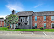 Thumbnail 11 of 26 - A large brick building with a black garage door in front.