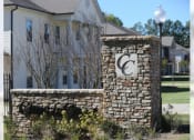 Thumbnail 2 of 16 - a stone wall with a cc on it in front of a house