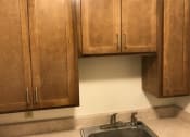 Thumbnail 4 of 15 - a kitchen with wooden cabinets and a sink