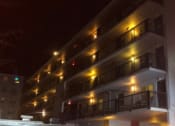 Thumbnail 13 of 15 - a night view of a hotel with lights on the balconies
