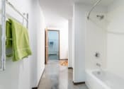 Thumbnail 9 of 34 - a bathroom with a white tub and a shower and a green towel