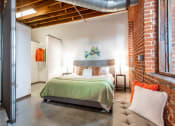 Thumbnail 4 of 34 - a bedroom with a bed and a exposed brick wall