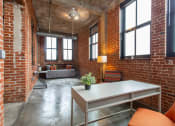 Thumbnail 2 of 34 - a living room with brick walls and a table and chairs