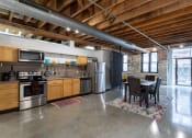 Thumbnail 16 of 34 - a kitchen with stainless steel appliances and a dining table
