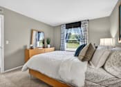 Thumbnail 19 of 31 - A bedroom with a large bed and a window with curtains.