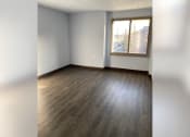 Thumbnail 18 of 22 - an empty living room with wood floors and a window