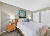 Thumbnail 21 of 31 - A bedroom with a large bed and a painting on the wall.