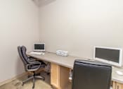 Thumbnail 14 of 16 - A small office with a desk, two chairs, and two computers.