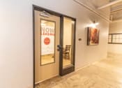 Thumbnail 11 of 16 - A door with a sign that says "NOW LEASING" is open.