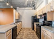 Thumbnail 1 of 16 - A kitchen with black appliances and wooden cabinets.
