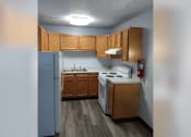 Thumbnail 16 of 22 - a kitchen with wooden cabinets and a white stove and refrigerator