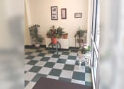 Thumbnail 5 of 15 - a room with a checkered floor and potted plants
