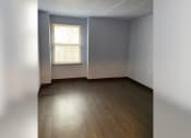 Thumbnail 9 of 22 - an empty room with wood floors and a window