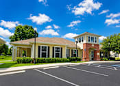 Thumbnail 2 of 15 - A building with a parking lot in front of it.