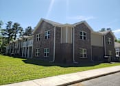 Thumbnail 5 of 11 - A row of houses with a sunny sky above them.