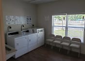 Thumbnail 10 of 11 - A laundry room with washers and dryers and a sign on the wall.