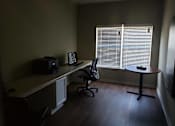 Thumbnail 11 of 11 - A room with a desk, chair, and a computer monitor.