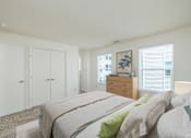 Thumbnail 7 of 19 - A bedroom with a bed, dresser, and wardrobe.