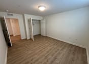 Thumbnail 7 of 9 - A room with a wooden floor and white walls.