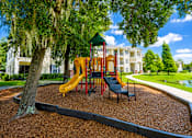 Thumbnail 6 of 15 - A playground with a yellow slide and a green canopy.