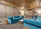 Thumbnail 38 of 39 - a living room with blue couches and a black and white carpet at Metro67, Tennessee, 38103